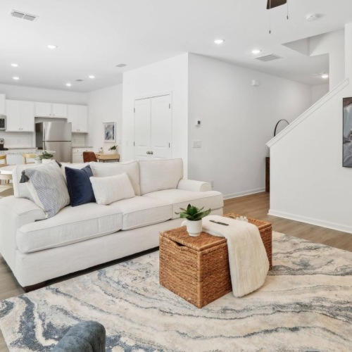 Generous living spaces with beautiful natural lighting a living room with a couch and a table